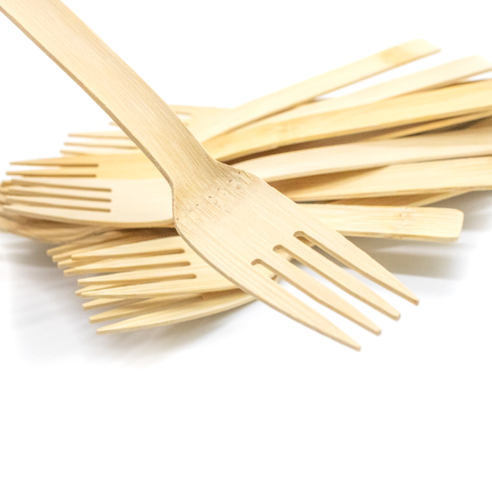 a small pile of wooden forks, with one fork further towards the viewer and in focus